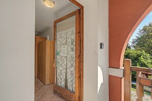 Una porta in legno con un vetrino, una parete bianca e una ringhiera in legno.