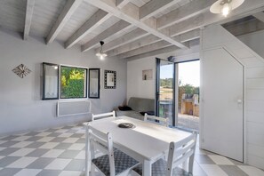 Een modern interieur met een geruit vloertje, witte meubels en een balkon met uitzicht.