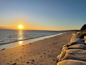 Ein Strand mit einer Reihe großer Felsen entlang der Küste.