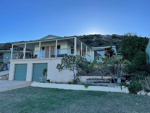 A two-story house with a balcony, a garage, and a well-maintained garden.
