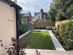 A well-maintained backyard with a lawn, a wooden fence, and a shed. - 11 Sandhurst Avenue (Lytham St. Anne's)