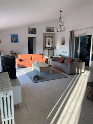 Ein Wohnzimmer mit einer Couch, einem Couchtisch und einem Fernseher.