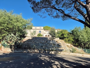 Ein Gebäude mit einer Steinmauer, Bäumen und blauem Himmel.