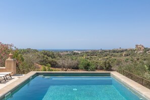 A clear swimming pool with a view of a hilly landscape and distant buildings. - Holiday Home 'Ca Na Tonina' with Sea Views and Private Pool (S'Alqueria Blanca)