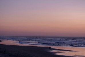 A beach with waves, a clear sky, and a few people walking. - Air-conditioned, comfortable new house, ideal for families and friends. (Biscarrosse)