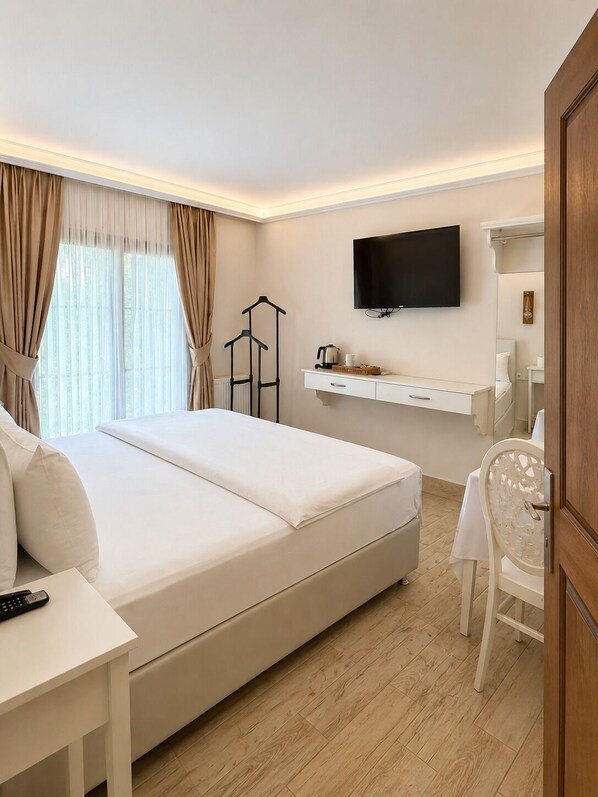 Una habitación de hotel con una cama grande, un escritorio, una silla, un televisor y un armario.