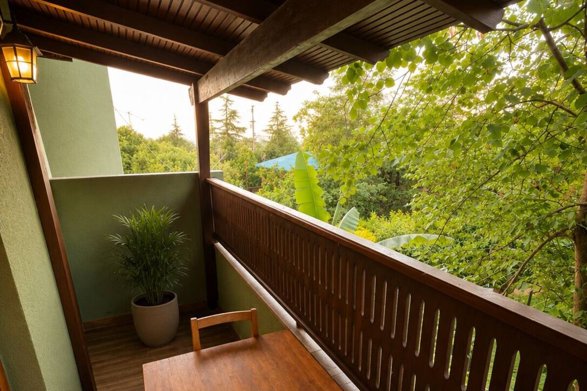 Una mesa de madera con un cuenco de metal, una planta en maceta y vistas a la vegetación a través de una cerca de madera.