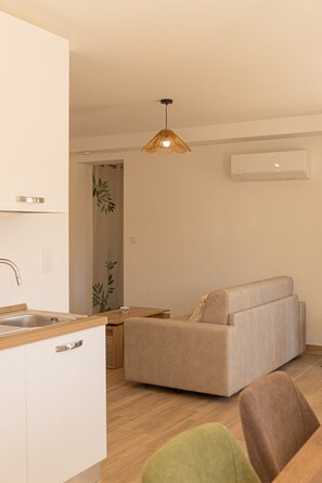 Eine moderne Küche mit Spüle, einem Essbereich inklusive Sofa und einer Pendelleuchte.