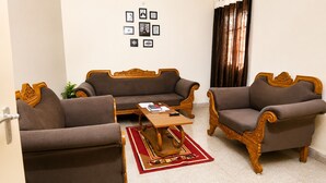 A living room with a sofa set, a coffee table, and a rug. - Hotel Imperial Garden (Patna)