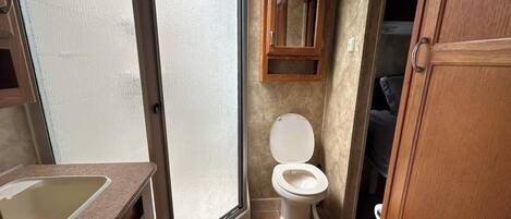 Un baño con inodoro, lavabo y espejo.