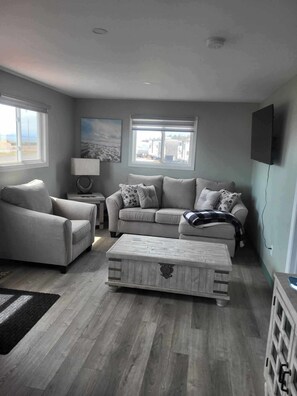 Una sala de estar con un sofá, un sillón y una mesa de centro.