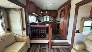 A compact RV interior with a kitchenette, a dining area, and a seating space. - What a View Cheticamp (Chéticamp)