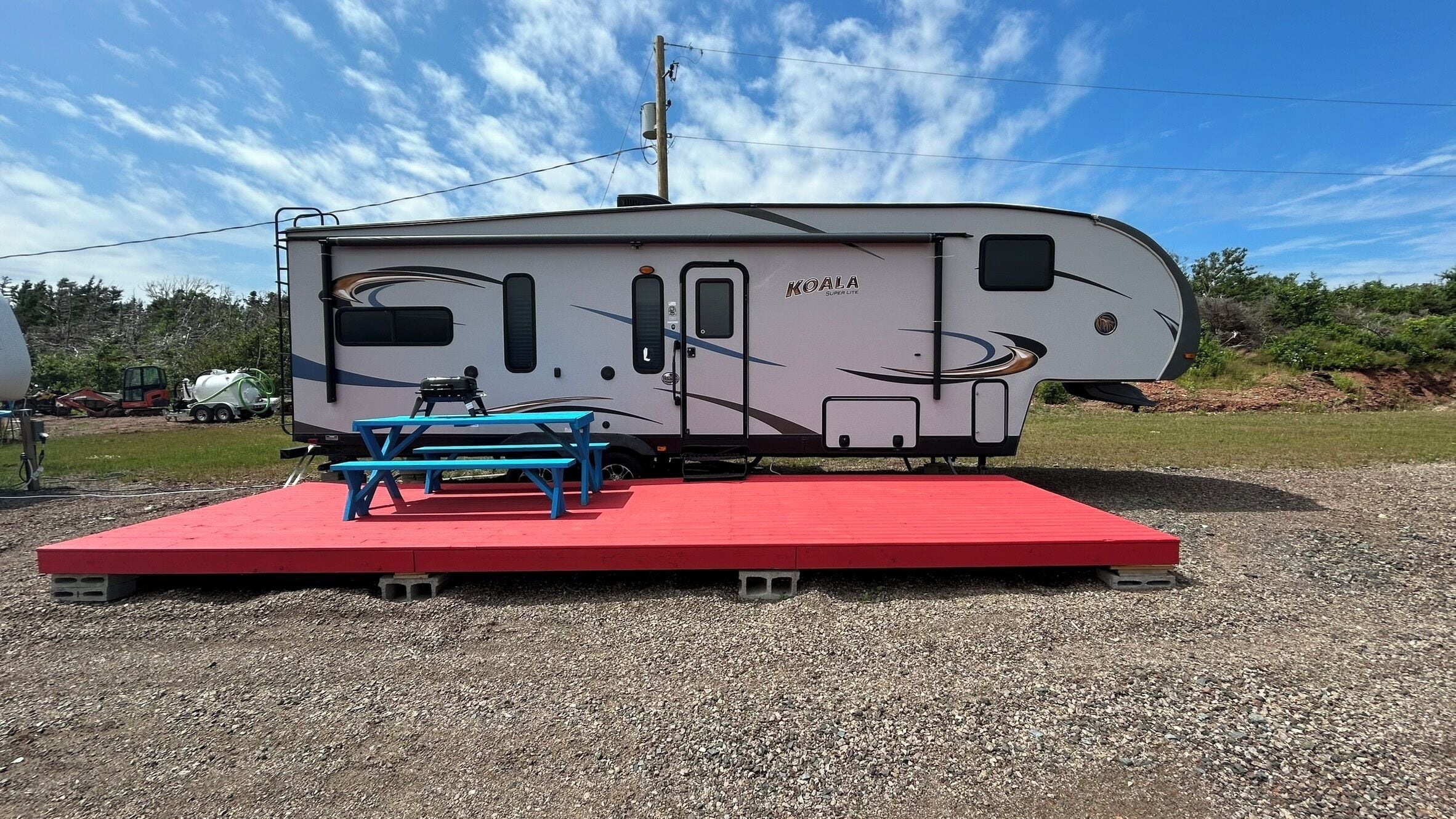 A KOALA Super Life RV with a picnic table and a red platform.