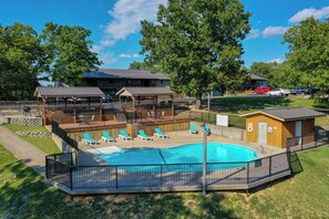 A swimming pool with lounge chairs, a covered deck, and a small building. - No-Stairs 2BR Branson Retreat w/ Pool, King Bed & SDC (Reeds Spring)