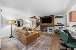 A modern living room with a sofa, coffee table, and a fireplace. - Modern 3BR Keystone Condo · Sleeps 6 · Walk to Lake, Minutes to Golf (Keystone)