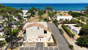 A residential area with a large house, a parking lot, and a view of the sea. - Apartment 'Residence La Dolce Vita' with Sea View, Wi-Fi and Air Conditioning (Borgo)