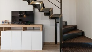 A modern kitchen with a built-in stove, a dining table, and a staircase with metal steps. - Apartment 'Residence La Dolce Vita' with Sea View, Wi-Fi and Air Conditioning (Borgo)