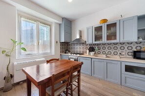 Una cucina con tavolo da pranzo, sedie, fornello e mobili.