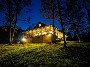 A modern house with large windows, a wooden exterior, and a grassy lawn. - Lakefront Paradise in Double Springs, AL 6BR Cabin with Private Dock (Double Springs)