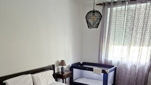 A bedroom with a bed, bedside table, lamp, and curtains. - T1 University of the Azores P. Delgada (PONTA DELGADA)