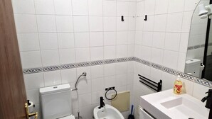 A bathroom with a toilet, bidet, sink, and mirror. - T1 University of the Azores P. Delgada (PONTA DELGADA)