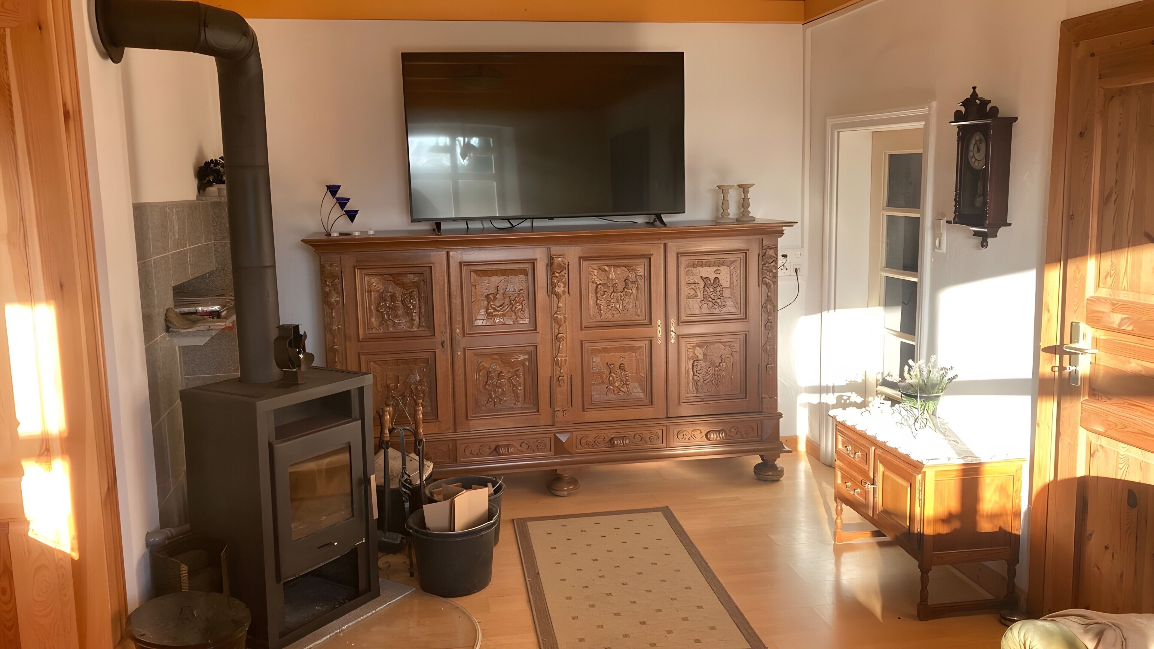 Ein Wohnzimmer mit Kamin, Fernseher und Holzschrank.