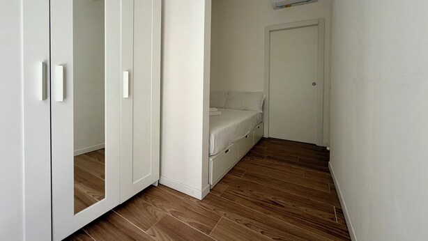 Ein Schlafzimmer mit Kleiderschrank, Bett und Klimaanlage.