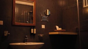 Een badkamer met een wastafel, spiegel, handdoekrek en toiletartikelen.