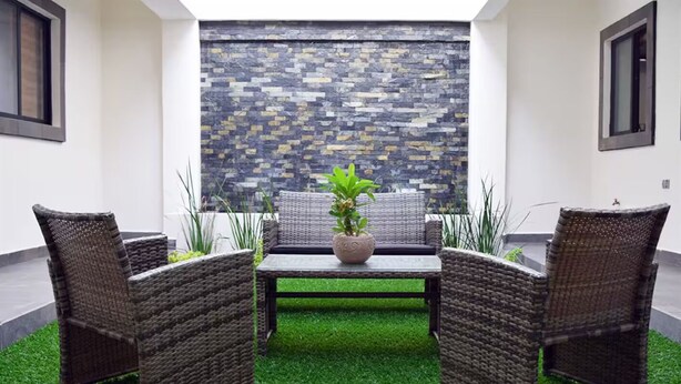A patio with wicker furniture, a central table, and a potted plant. - Luxury apartment #4 steps away from IMSS / UMAE (Ciudad Obregón)