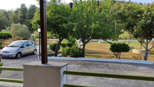 A car parked on a paved area with trees and a grassy field in the background. - Skopelos Cozy Escape Near The Forest the Sea (Skopelos)