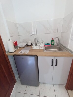 Eine kleine Küche mit Spülmaschine, Spüle und Arbeitsplatte mit verschiedenen Küchenutensilien.
