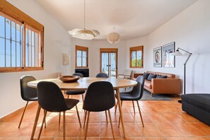 Een eetruimte met een ronde tafel, stoelen en een houten vloer.