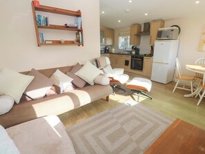 Ein modernes Wohnzimmer mit einer Couch, einem Couchtisch und einem Essbereich mit einem Stuhl und Tisch.