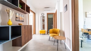 A modern interior with a sofa, a small table, and a decorative vase. - GuestHost - Modern Flat X4 near the Center (Trieste)