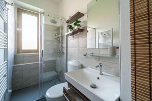 A modern bathroom with a glass shower enclosure, a white sink, and a toilet. - GuestHost - Modern Flat X4 near the Center (Trieste)