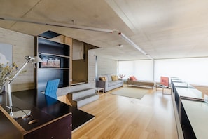Ein moderner Arbeitsbereich mit Schreibtisch, Computer und einer Couch.