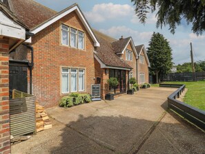 A brick house with a driveway, a guest parking sign, and a small garden area. - Denmark House (Chatham)