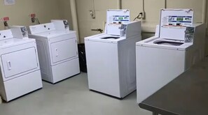 A laundry facility with multiple washing machines and dryers.