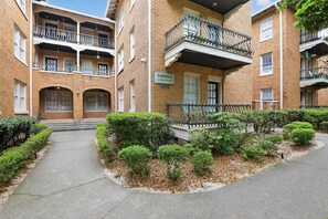 Useita kerroksia sisältävä tiilirakennus, jonka yläpuolella on kyltti, jossa lukee: ”Warwick Apartments”.