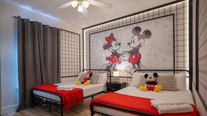 A hotel room with two beds, a Mickey Mouse mural, and a ceiling fan. - Disney 3BR Villa in Lucaya Harbor Resort (Kisssimmee)