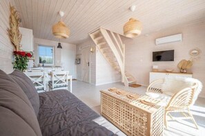 Ein modernes Interieur mit Treppe, Sofa, Essbereich und Fernseher.