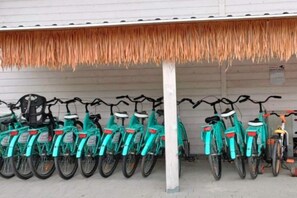 A row of bicycles parked under a thatched roof structure. - Holiday home with terrace, garden, and pool (Kopan)