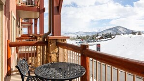 A balcony with a table and chairs, overlooking a snowy mountain landscape. - 2 bdrm Ski in/Ski out Westgate Resort in Beautiful Park City (Park City)