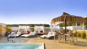 A poolside area with lounge chairs, a thatched umbrella, and a white tent structure. - Holiday home with garden, air conditioning, pool (Kopan)