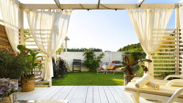 A covered outdoor area with a wooden deck, a barbecue grill, and a poolside lounge chair. - Holiday home with garden, air conditioning, pool (Kopan)