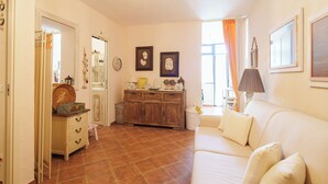 A living room with a sofa, a cabinet, and a door leading to another room. - Incanto Retreat with Terrace – Golfo Aranci (Punta Pedrosa)