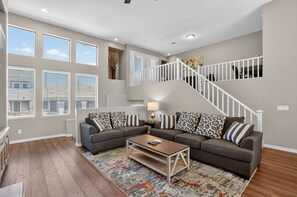 A living room with a sectional sofa, a coffee table, and a staircase. - NEW! Scottsdale Basecamp with Prime Golf Access (Scottsdale)
