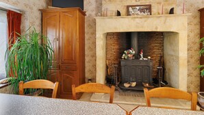 Un coin repas avec une cheminée, des meubles en bois et une plante.