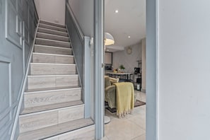 A staircase with wooden steps leading to a living area with a sofa and a coffee table.