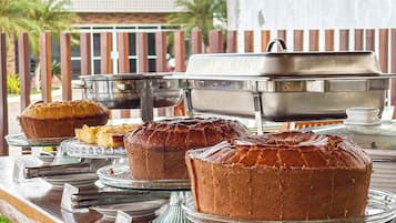 A buffet setup with various baked goods on display.
